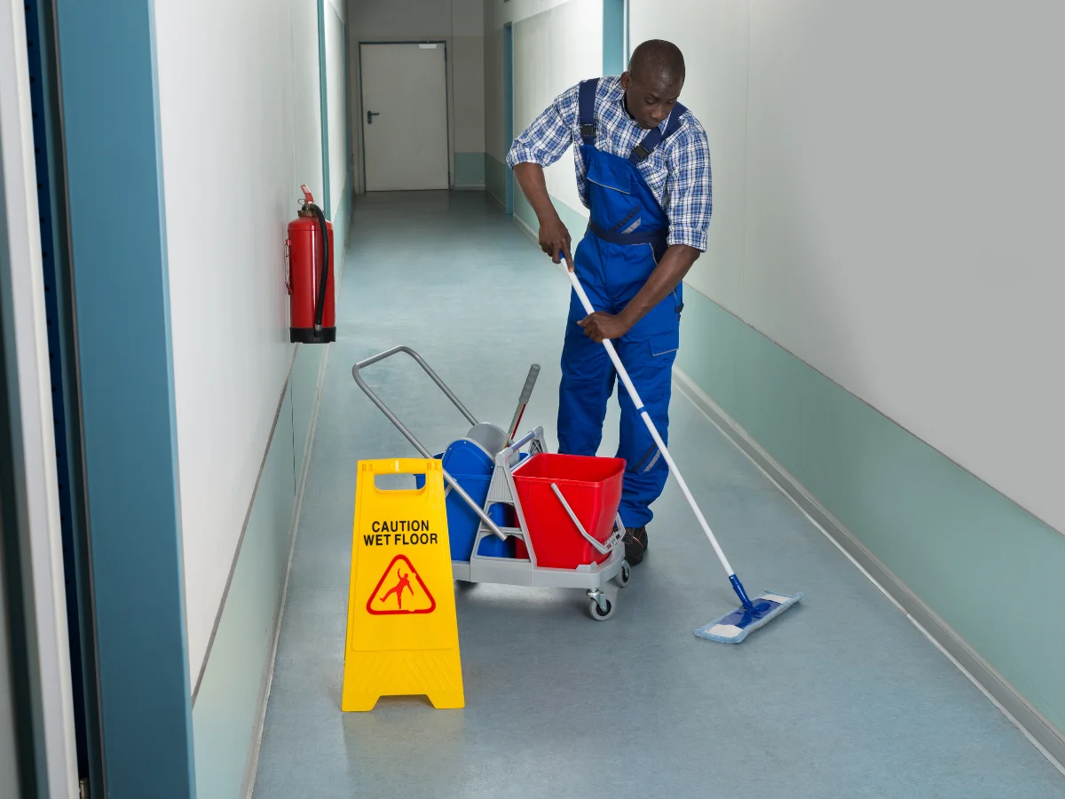 A professional cleaner mopping the classroom hallway.