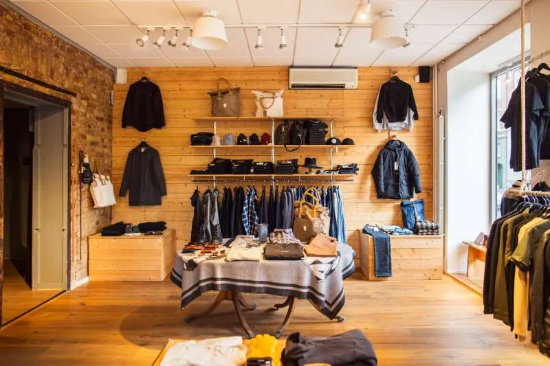 Rustic clothing store features light wood paneling