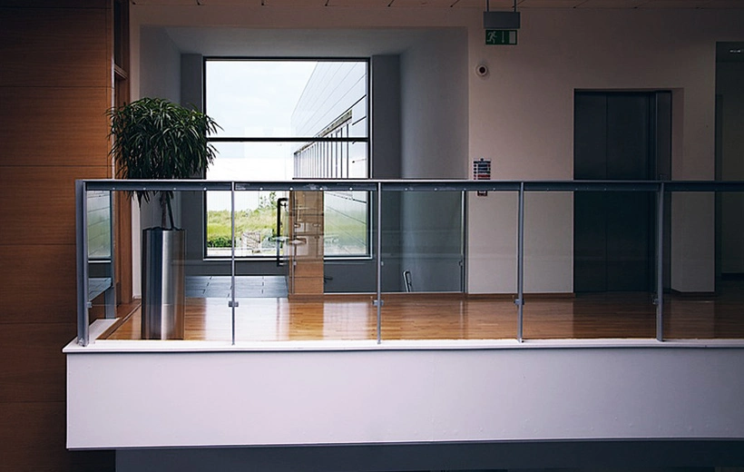gallery-image-06 office interior features a modern glass railing with a brushed metal cylindrical planter